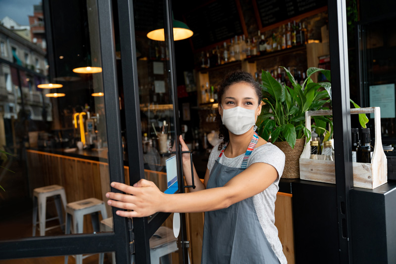 femme masquée près de son café